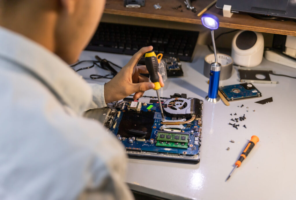 computer repair technician repairing a laptop