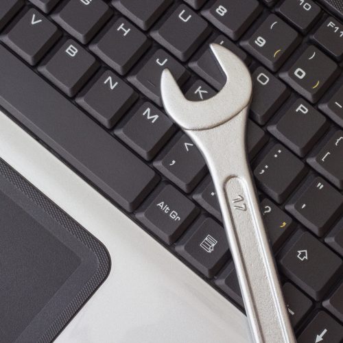 spanner on the laptop keyboard, the concept of repairing machinery